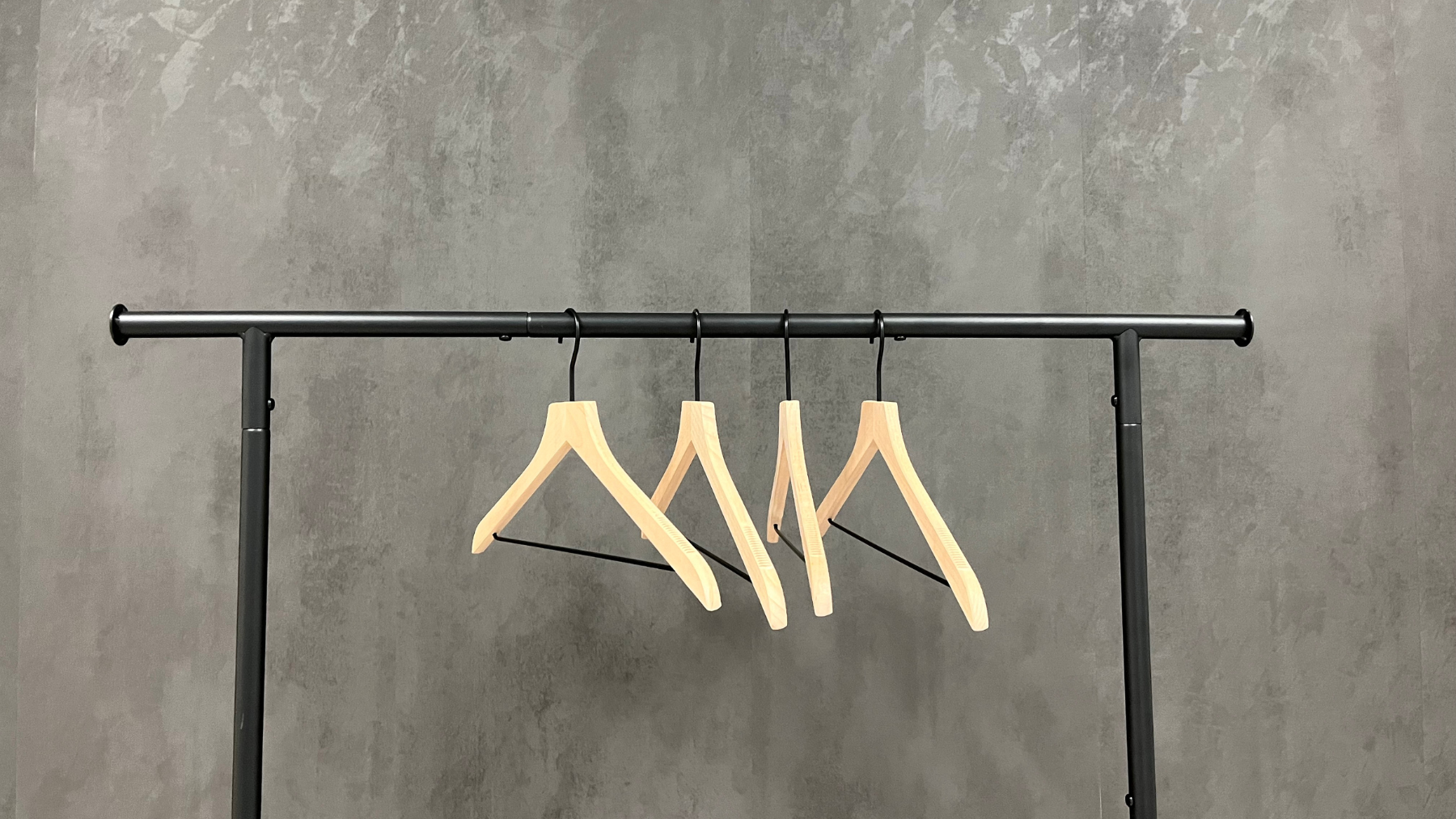 An empty clothing rack with wooden hangers.